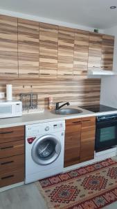 a kitchen with a washing machine and a sink at Szoba konyha lakas in Komárno