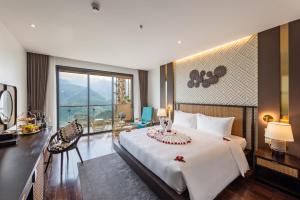 a bedroom with a large bed and a large window at KK Sapa Hotel in Sa Pa