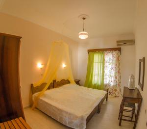 Schlafzimmer mit einem Bett mit Moskitonetz in der Unterkunft Takis Apartments in Sidari
