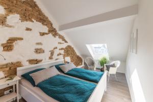 a bedroom with a bed and a stone wall at Ferienwohnungen in Losheim am See in Losheim