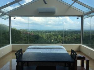 - une chambre avec un lit en face d'une grande fenêtre dans l'établissement Sky Retreat - Sri Lanka, à Gampaha