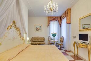 ein Schlafzimmer mit einem großen Bett und einem Kronleuchter in der Unterkunft Hotel At Leonard in Venedig