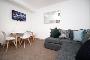 a living room with a couch and a table at Stay in the Heart of Swansea- TV in Every Bedroom! in Swansea