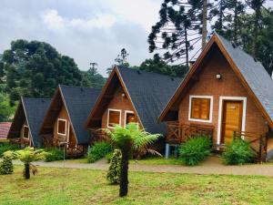 a wooden house with a gambrel roof at Chalés Amabilis in Monte Verde