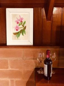 a bottle of wine sitting next to a wine glass at Chalés Amabilis in Monte Verde +18 photos
