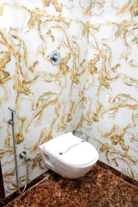 um WC branco numa casa de banho com uma parede em mármore em Hotel Nest N Rest - Mumbai em Mumbai