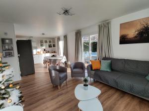 a living room with a couch and a christmas tree at LV Holidays 2 in Savigny-en-véron