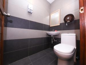 a bathroom with a toilet and a sink at Super OYO 910 Hills Residence in Kuching