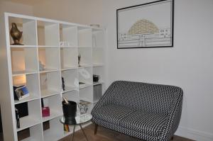 a room with a chair and a book shelf at LE NID DES HALLES, au cœur du Boulingrin in Reims