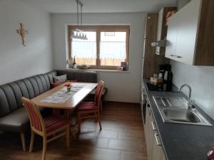 a kitchen with a table and chairs and a sink at Apart Waldesruh in Arzl im Pitztal