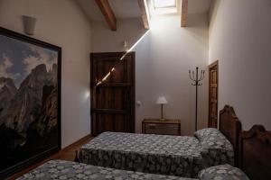 1 dormitorio con 2 camas y un cuadro en la pared en Apartamento en casa del s.XVI, en Trujillo