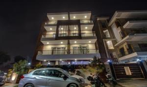 un'auto parcheggiata di fronte a un edificio di notte di Treebo M2M Residency Sector 46 a Gurgaon