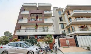 un'auto parcheggiata di fronte a un edificio con moto di Treebo M2M Residency Sector 46 a Gurgaon