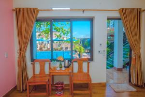 ein Esszimmer mit einem Tisch, Stühlen und einem Fenster in der Unterkunft Lucky Homes in Phong Nha