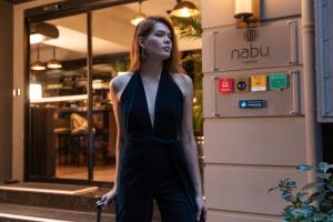 Uma mulher de vestido preto à porta de uma loja. em Nabu Hotel Karaköy em Istambul