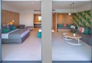 a bedroom with a bed and a living room at Skiathos Palace Hotel in Koukounaries