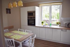 a kitchen with white cabinets and a table and a window at Cozy apartment in Tarnow in Tarnów