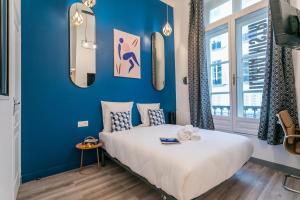 Un dormitorio con una pared azul y una cama en Apartments WS Marais - République en París