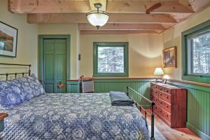 a bedroom with a bed and a dresser and two windows at Waterfront Denmark Complex with Dock on 12 Acres! in Denmark