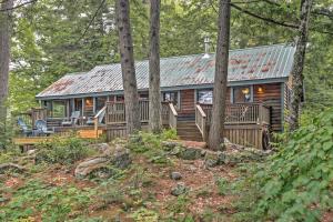 a log cabin in the woods with a metal roof at Waterfront Denmark Complex with Dock on 12 Acres! in Denmark
