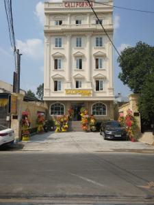 un gran edificio blanco con un cartel. en California Hotel, en Ho Chi Minh