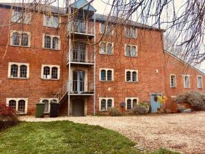 a large brick building with a staircase in front of it at B&B at The Old Mill in Devizes