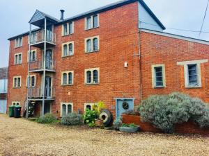 a large red brick building with a balcony at B&B at The Old Mill in Devizes