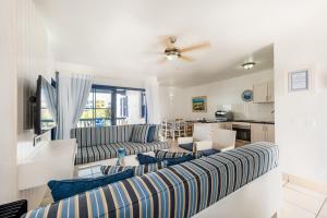 a living room with a couch and a kitchen at Club Mykonos Langebaan in Langebaan