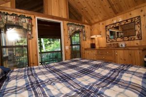 Un dormitorio con una cama grande en una cabaña. en Family Cabin on 6 Acres with Lake Access and Hot Tub!, en Springfield