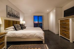 1 dormitorio con cama grande y ventana grande en Club Mykonos Langebaan en Langebaan