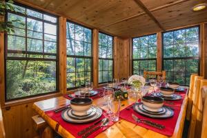 ein Esszimmer mit einem Tisch mit Tellern und Gläsern in der Unterkunft Family Cabin on 6 Acres with Lake Access and Hot Tub! in Springfield