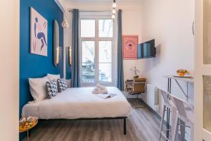 a bedroom with a bed and a blue wall at Apartments WS Marais - République in Paris