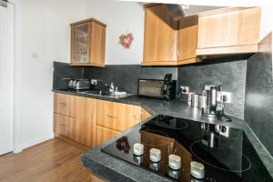 a kitchen with a black counter top and wooden cabinets at Bridge Street in Banff