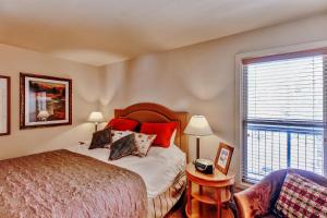a bedroom with a bed with red pillows and a window at Bend Condo with Deck, Resort-Style Amenities and Views! in Bend