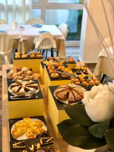 uma mesa com caixas cheias de diferentes tipos de produtos de pastelaria em Hotel Carmen em Riccione