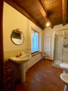 La salle de bains est pourvue d'un lavabo et d'un miroir. dans l'établissement Agriturismo Corte Moranda, à Novaglie