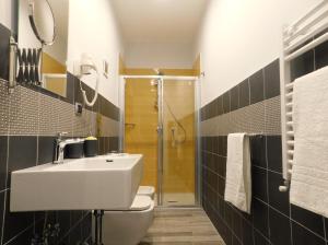 e bagno con lavandino, servizi igienici e doccia. di Scaramantico Rooms a Napoli