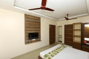 a bedroom with a ceiling fan and a tv at Sri Kamadhenu Residency in Coimbatore