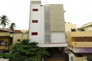 wysoki biały budynek na szczycie miasta w obiekcie Sri Kamadhenu Residency w mieście Coimbatore