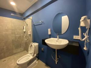a bathroom with a sink and a toilet and a mirror at Nap Hotel in Chiang Rai