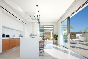 a kitchen with white walls and a large window at Thalassa in Paphos City