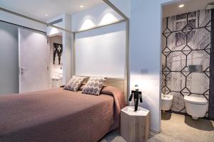 ein Schlafzimmer mit einem Bett und ein Badezimmer mit einem Waschbecken in der Unterkunft La Loggia Grand Canal in Venedig