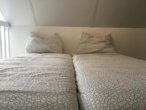 a white bed with two pillows on top of it at Slaapplaatsen 2-4 personen voor bezoek DTRH of Goffertconcert Bruce Springsteen-Rammstein in Beuningen
