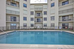 オーモンド・ビーチにあるOceanfront Ormond Beach Condo with Pool Access!のアパートメントの建物の前にスイミングプールがあります。
