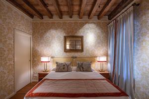 a bedroom with a large bed with two lamps at Ca' Belle Arti in Dorsoduro in Venice