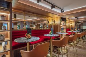 a restaurant with red booths and tables and chairs at Meliá White House Hotel Apartments in London