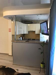 a kitchen with white cabinets and a tv on a counter at Квартира Апполо in Dnipro