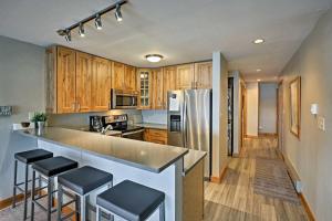 a kitchen with wooden cabinets and a stainless steel refrigerator at Mtn-View Condo with Hot Tub Access in Dillon! in Dillon