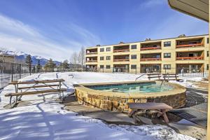 a building with a swimming pool in the snow at Mtn-View Condo with Hot Tub Access in Dillon! in Dillon