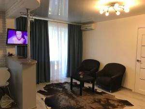 - un salon avec deux chaises et une télévision à écran plat dans l'établissement Квартира Апполо, à Dnipro